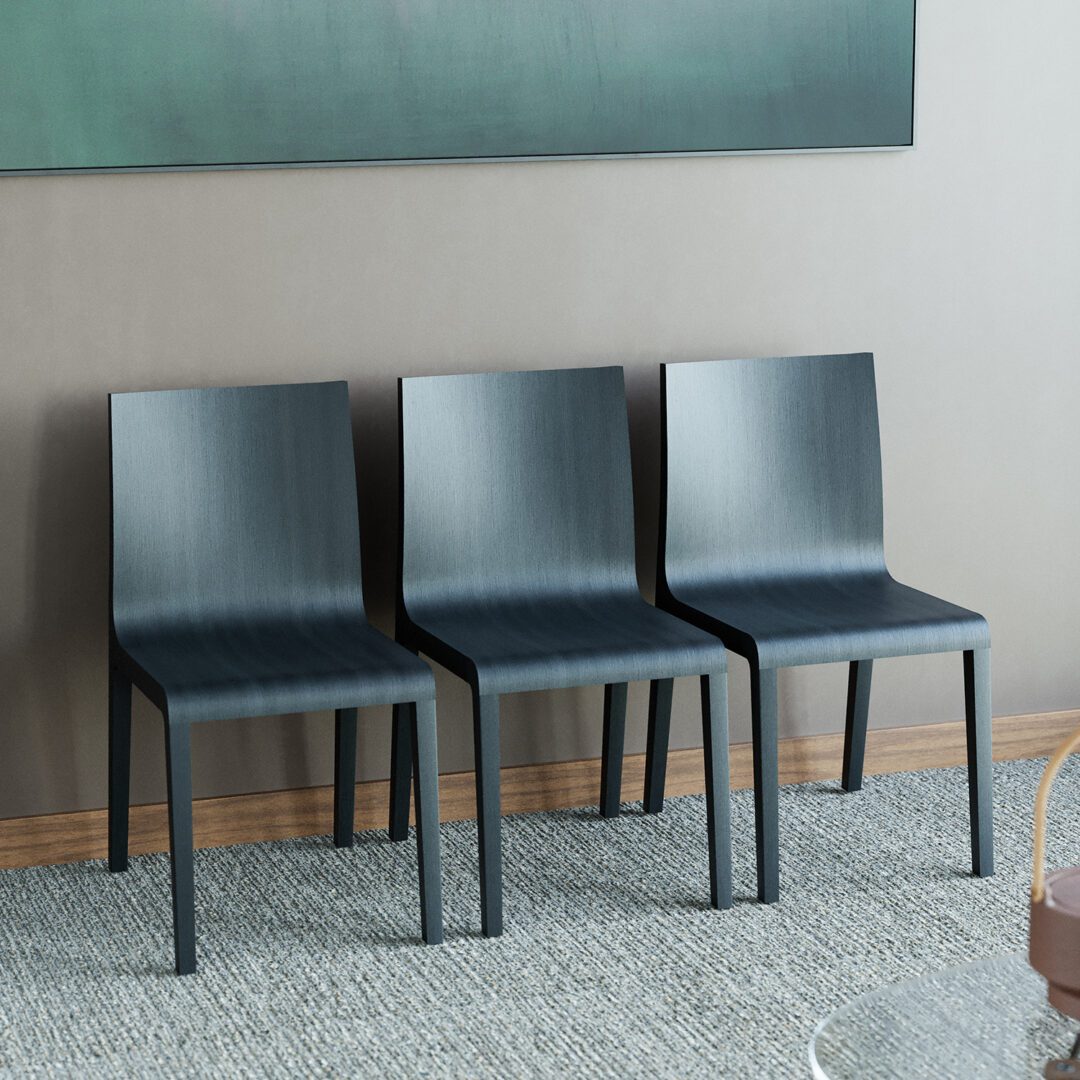 Three black minimalist visitor chairs against the wall with artwork in the background.